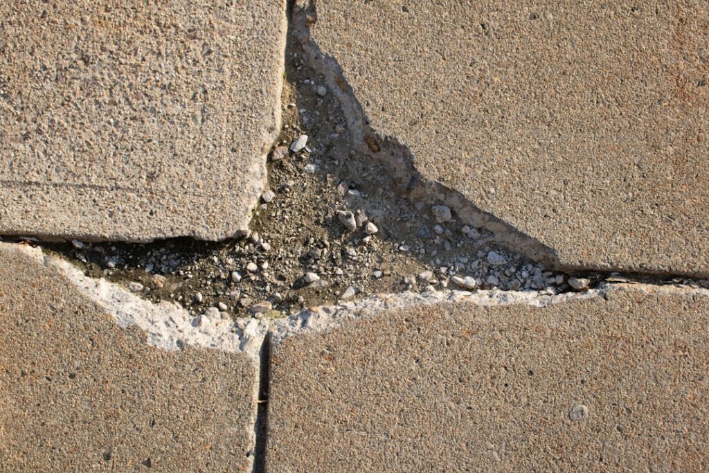 closeup of a large crack in a concrete driveway
