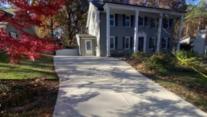 Newly poured concrete driveway for a two-story gray colonial home in Raleigh, North Carolina.