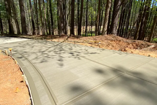 Newly installed reinforced concrete driveway in Apex, NC, showcasing a professional broom finish and framed joints