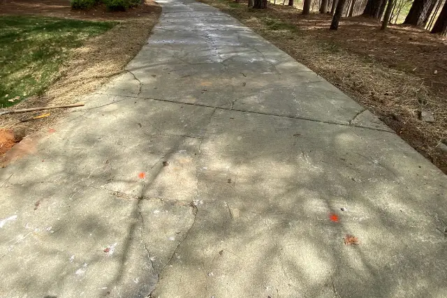 Cracked and deteriorated concrete driveway before replacement in Buckingham Apex, NC