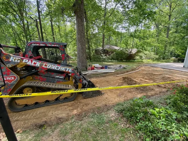 Residential driveway demolition and concrete removal using an excavator in Cary, North Carolina